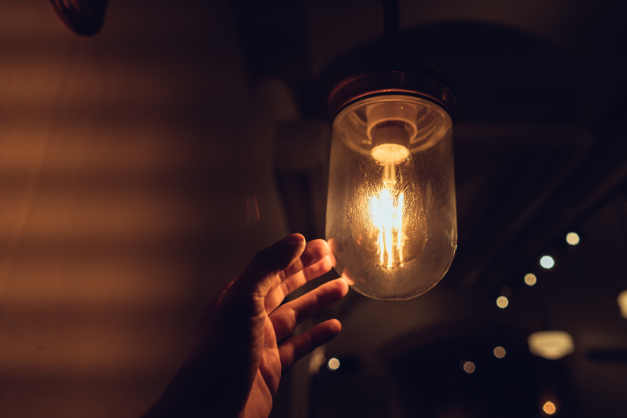 Center hand reaching vintage light bulb